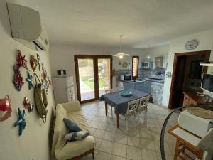 a kitchen and dining room with a table in a room at L'Incanto Tanca Piras in Nebida