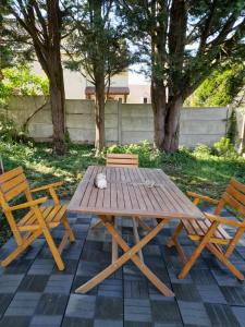 einen Picknicktisch aus Holz und zwei Stühle auf einer Terrasse in der Unterkunft maison entiere au calme in Montgeron