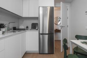 a stainless steel refrigerator in a kitchen with white cabinets at tuGuest Mirador Norte in Granada