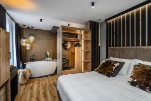 ein Schlafzimmer mit einer Badewanne, einem Bett und einem Waschbecken in der Unterkunft Hotel Folgarida in Folgarida