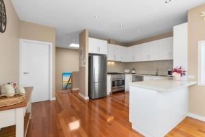 an empty kitchen with a stainless steel refrigerator at Over the dunes to the beach in seconds in Ocean Grove