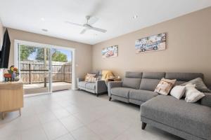 a living room with a couch and a table at Over the dunes to the beach in seconds in Ocean Grove