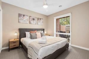 a bedroom with a large bed and a window at Over the dunes to the beach in seconds in Ocean Grove +9 photos