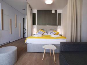 - une chambre avec un grand lit et un canapé dans l'établissement MK Apartamenty Młyńska 10 II, à Kołobrzeg