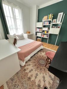 Apartment near to Paris (7 minutes) في أسنيير-سور-سين: غرفة نوم مع سرير ورف كتاب