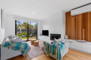 a living room with a couch and a fireplace at Sundrenched Barwon Heads in Barwon Heads