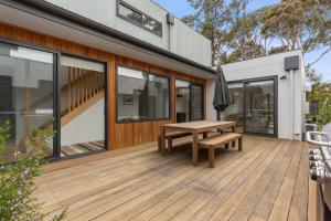 a wooden deck with a wooden bench on a house at Sundrenched Barwon Heads in Barwon Heads