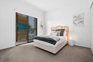 ein Schlafzimmer mit einem Bett und einem großen Fenster in der Unterkunft Park View Coastal Oasis Barwon Heads Pet friendly in Barwon Heads