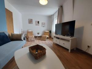 uma sala de estar com um sofá e uma televisão de ecrã plano em Cozy Home, 7 Beds, WiFi, Kitchen, Balcony, Bielefeld Center em Bielefeld
