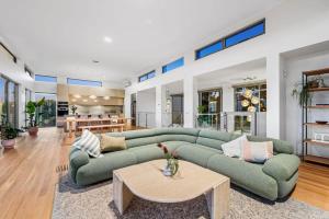 a living room with a green couch and a table at Waterline in Bellbrae