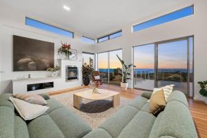 a living room with a blue couch and a tv at Waterline in Bellbrae +24 photos