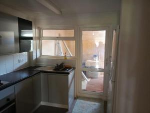 una pequeña cocina con ventana y fregadero en Remarkable 4-Bed House in Chatham, en Chatham