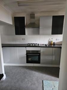 a kitchen with white cabinets and a stove at Remarkable 4-Bed House in Chatham in Chatham