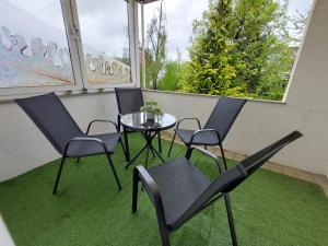 a patio with four chairs and a table and a window at Cozy Home, 7 Beds, WiFi, Kitchen, Balcony, Bielefeld Center in Bielefeld