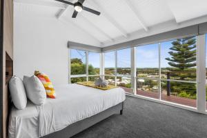 a bedroom with a bed and a large window at Endless Dune Views Beach House in Ocean Grove
