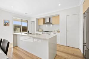 a white kitchen with a large white counter top at Park Front Villa with sparkling swimming pool in Saint Leonards