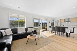 a living room with a black couch and a table at Park Front Villa with sparkling swimming pool in Saint Leonards