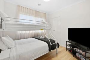 a bedroom with a bunk bed and a flat screen tv at Park Front Villa with sparkling swimming pool in Saint Leonards