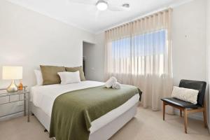 a bedroom with a large bed and a window at Park Front Villa with sparkling swimming pool in Saint Leonards