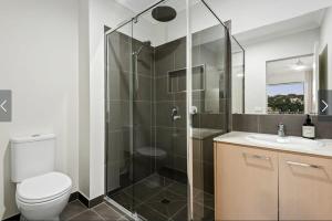 a bathroom with a shower and a toilet and a sink at Park Front Villa with sparkling swimming pool in Saint Leonards
