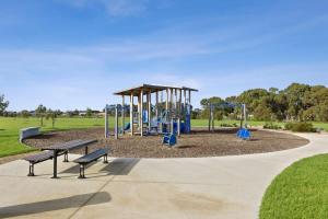 a park with a playground with benches and swings at Park Front Villa with sparkling swimming pool in Saint Leonards
