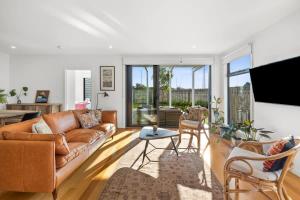 a living room with a couch and a table at Saltbush By The Park in Torquay