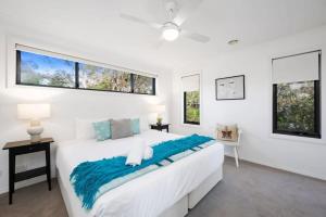 a white bedroom with a large bed and two windows at Holiday Haven - Coastal Comfort in Old Torquay in Torquay