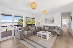 a living room with a couch and a table at Blue Seas Beach House, 400 metres to the beach in Ocean Grove