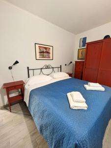 een slaapkamer met een blauw bed en handdoeken bij La Sartoria - Casetta napoletana in Napels