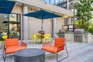 a patio with chairs and a table with an umbrella at Blueground Mountain View gym pool near retail SFO-1715 in Los Altos