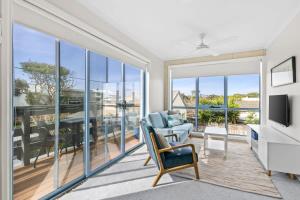 a living room with sliding glass doors and a television at Coastal Serenity Central Torquay in Torquay