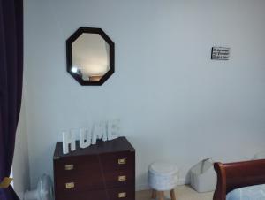 a bedroom with a dresser and a mirror on the wall at L'Écluse in Dieppe
