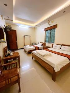 1 dormitorio con 2 camas y mesa en Khách sạn Đức Tài, en Bảo Lạc