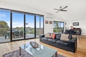 a living room with a couch and a table at Seaview Sanctuary Jan Juc Distant Ocean View in Torquay