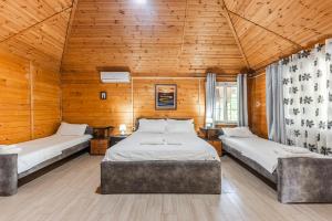 2 łóżka w pokoju z drewnianymi ścianami w obiekcie Kompleksi Aljoma w mieście Fushë-Draç