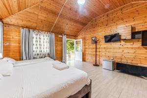 sypialnia z dużym łóżkiem w drewnianej ścianie w obiekcie Kompleksi Aljoma w mieście Fushë-Draç