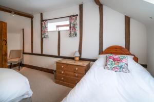 A bed or beds in a room at The Granary self-catering cottage on a working farm