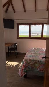 um quarto com uma cama, uma mesa e uma janela em Villas del Mar em Las Tunas