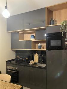 a kitchen with a stainless steel refrigerator and a sink at Casa da vila in Faro