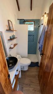 uma casa de banho com um lavatório preto e um WC. em Villas del Mar em Las Tunas