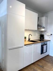 a white kitchen with white cabinets and a sink at Arbio Monteurzimmer Behnitzer Parking included in Nauen