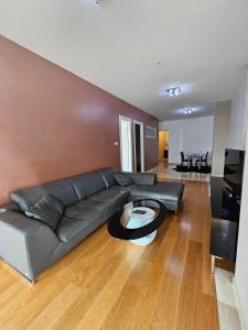 uma sala de estar com um sofá de couro preto e uma mesa em Tecasi Lux Apartments em Budva
