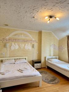 1 dormitorio con 2 camas y techo en Trio Hotel Restaurant, en Ivano-Frankivsk