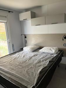 ein Bett mit zwei Kissen darauf in einem Schlafzimmer in der Unterkunft Camping La Forêt Stella-Plage in Stella-Plage