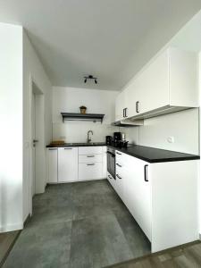 a kitchen with white cabinets and a black counter top at Elegantes 2 Zimmer Apartment Top Lage in Bruchsal