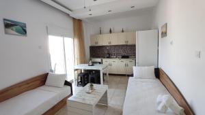 a living room with two white couches and a kitchen at Wave Sound Apartments - Village View in Skala Marion +26 photos