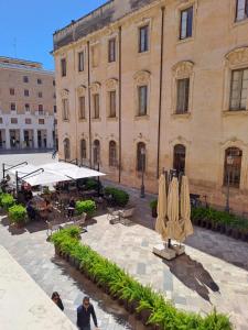 a building with a courtyard with tables and umbrellas at Dimora Vico Storella in Lecce