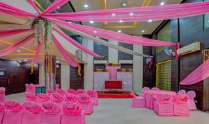 a room with pink chairs and a table with a tent at Treebo Bliss in Jaipur