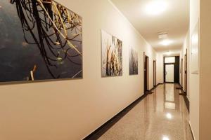 a hallway with paintings on the walls of a building at Ukiel Park J&J in Olsztyn