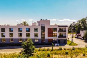 a large white building with a lot of windows at Ukiel Park J&J in Olsztyn
